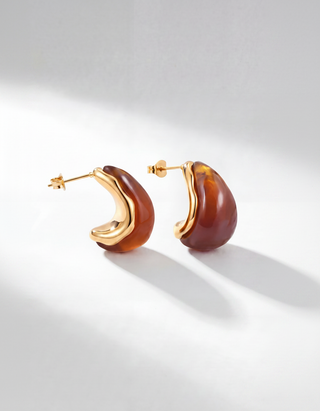 Ambera Ohrstecker in Amber – marmoriertes braunes Resin in Tropfenform mit 18K PVD-vergoldeter
Fassung